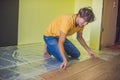 Man installing new wooden laminate flooring. infrared floor heat Royalty Free Stock Photo