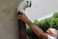 Close-Up of Man Installing Outdoor Tin Stovepipe for Wood-Burning Stove Royalty Free Stock Photo