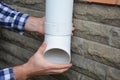 Man installing plastic rain gutter system pipeline. Guttering, Gutters, Plastic Guttering, Guttering & Drainage by Handyman hand Royalty Free Stock Photo