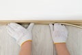 Man installing plinth on laminated floor in room, top view Royalty Free Stock Photo