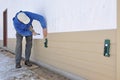 Man installing siding using gauges