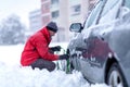 Man installing snow chain on car