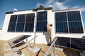 Man installing solar panels on a rooftop Royalty Free Stock Photo