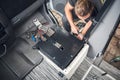 Man installing a swivel seat base in his camper van