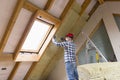 Man installing thermal roof insulation layer - using mineral woo