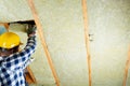 Man installing thermal roof insulation layer - using mineral woo