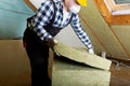 Man installing thermal roof insulation layer - using mineral woo