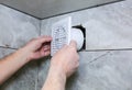 Man is installing the wall bathroom fan vent. Restoration process Royalty Free Stock Photo