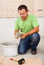 Man installs ceramic floor tiles - preparing the adhesive