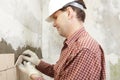 Man installs ceramic tile