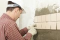 Man installs ceramic tile