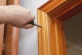 A man installs a wooden door trim. The hand screwdriver screws i Royalty Free Stock Photo