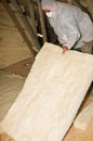 Man insulating a roof or attic of a newly built house with ceramic wool