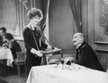 Man interacting with cigarette saleswoman in restaurant