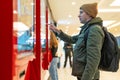 Man interacts with digital kiosk in modern mall, navigating touch screen. Technological integration into shopping Royalty Free Stock Photo