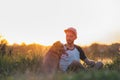 Man interacts with his dog in sunset, summer season.