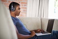 Man, internet and music with laptop on sofa for movie streaming, podcast and online games with listening. Young, black