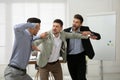 Man interrupting colleagues fight at work Royalty Free Stock Photo