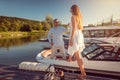 Man inviting a woman to his motorboat sitting in the river port Royalty Free Stock Photo