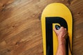 Man ironed wax on a snowboard, lying wooden floor