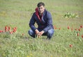 A man in a jacket on a field of tulips. Glade with tulips