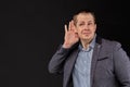 A man in a jacket hears important information on a black background