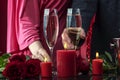 A man in a jacket and a woman in a pink dress are holding glasses of sparkling wine. Royalty Free Stock Photo