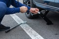 Man is jacking up broken car, wheel replacement. Tire replacement concept.