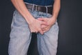 Man in jeans covers his crotch with hands Royalty Free Stock Photo