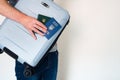 Man in jeans holding travel blue suitcase, ukrainian passport and green document