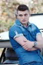 Man in jeans, leaning on an old damaged car Royalty Free Stock Photo