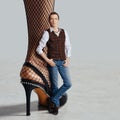 Man in jeans and vest leaning to female leg in fishnet tights and open heel stiletto Royalty Free Stock Photo