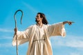 Man in jesus robe holding wooden cane