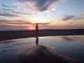 Man jogger running on sunset beach with reflection