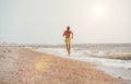 Man jogging on the desert sea line at the morning time Royalty Free Stock Photo