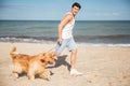 Man jogging and having fun with dog on the beach Royalty Free Stock Photo