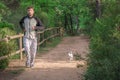 Man Jogging With His Dog In Park Trail In Afternoon