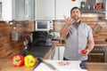Man juggling with tomatoes in his kitchen laughing Royalty Free Stock Photo