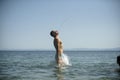Man jump out of sea with splashes of water. Vacation concept. Guy in swimwear make stream of water out of his mouth with Royalty Free Stock Photo