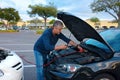 Man jump starting a car with jumper cables