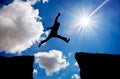 Man jumping across the gap from one rock to cling to the other.