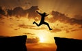 Man jumping across the gap from one rock to cling to the other. Royalty Free Stock Photo