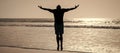 Man jumping, banner with copy space. healthy man silhouette raised hands on beach. energetic summer. feel freedom.