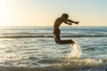 Man jumping on beach at sunset Royalty Free Stock Photo