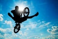 Man jumping on bmx bike performing a trick. Sunny sky