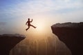 Man jumping from cliff on  sky and city background. Gap, leap, risk, challenge and success concept Royalty Free Stock Photo
