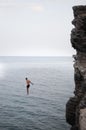 A man is jumping from a high cliff into the sea Royalty Free Stock Photo