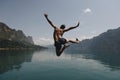 Man jumping with joy by a lake