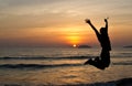 A man jumping in joy during a sunset in Tanjung Aru beach