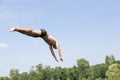 Man jumping off diving board at swimming pool